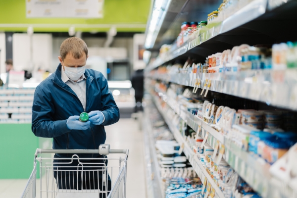 etiquetas de productos alimenticios; un hombre con cubrebocas en un supermercado checando el etiquetado del producto
