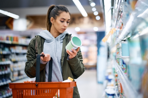 etiquetas de productos; una chica en un supermercado leyendo una etiqueta 