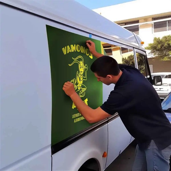 Vinil magnético; un hombre colocando en su vehículo un diseño de color verde