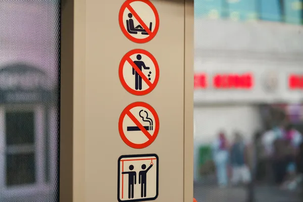 señalización industrial con imán en puerta de transporte colectivo con cuatro pictogramas de prohibición: no subir pies a los asientos, no tirar basura, no fumar y agarrarse con fuerza
